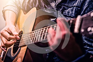 Woman`s hands playing acoustic guitar