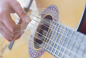 Woman`s hands playing acoustic guitar, close up