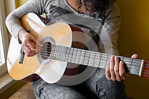 Woman`s hands playing acoustic guitar, close up