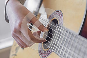 Woman`s hands playing acoustic guitar, close up