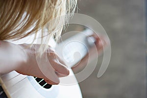 Woman`s hands playing acoustic guitar, close up