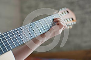 Woman`s hands playing acoustic guitar, close up