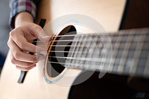Woman& x27;s hands playing acoustic guitar, close up