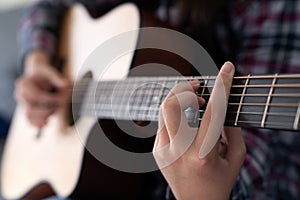 Woman& x27;s hands playing acoustic guitar, close up