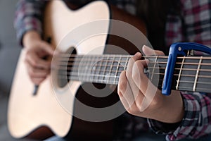 Woman& x27;s hands playing acoustic guitar, close up