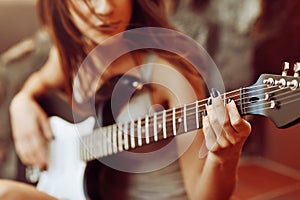 Woman's hands playing acoustic guitar, close up