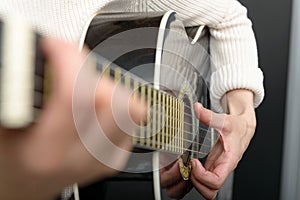 Woman`s hands playing acoustic guitar, close up