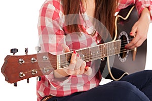 Woman's hands playing acoustic guitar, close up