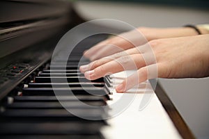 Woman`s hands playing electronic piano