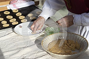 Woman`s hands preparing dough to make sweet rolls with typical costumes