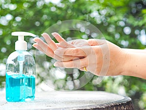 Woman's hands is pressing a bottle of Alcohol Gel to clean her hands.
