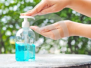 Woman`s hands is pressing a bottle of Alcohol Gel to clean her hands. Alcohol gel is very important in daily life.