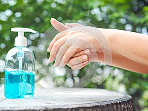 Woman`s hands is pressing a bottle of Alcohol Gel to clean her hands. Alcohol gel is very important in daily life.