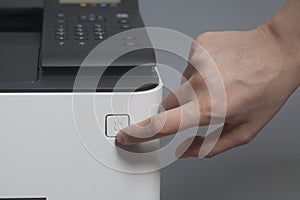 Woman`s hands pressing button on color laser printer