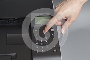 Woman`s hands pressing button on color laser printer