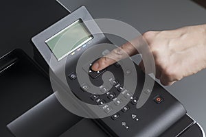 Woman`s hands pressing button on Control panel laser color printer