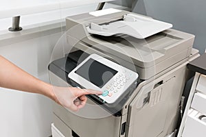 Woman`s hands pressing button on copy machine