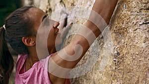 Woman`s hands reaching and holding rock holds on a yellow cliff