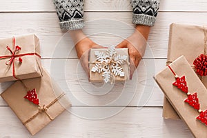 Woman`s hands show christmas holiday present with craft twine