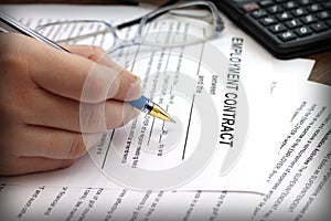 Woman's hands signing an employment contract