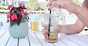 Woman's hands with a summer cocktail on the beach