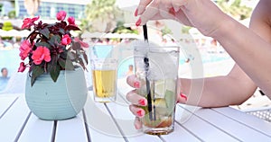 Woman's hands with a summer cocktail on the beach