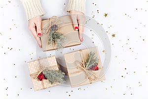 Woman`s hands and three Christmas gift boxes