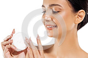 Woman`s hands are about to apply face cream. Holding moisturizing lotion. Close-up of girl face applying a moisturizer