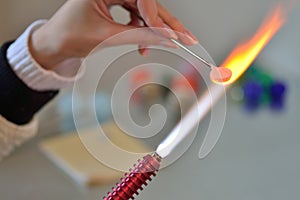 Woman's hands with tools for glass melting, the time of producti