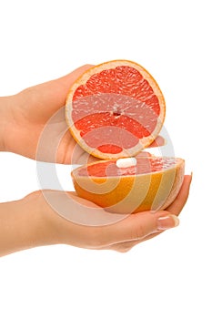 Woman`s hands with two pieces of grapefruit