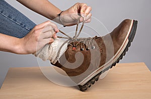 Woman's hands tying a bow on her walking boots