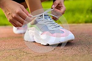 Woman`s hands tying the laces on the sneaker.