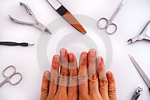 Woman`s hands with uncoated manicure and home manicure tools