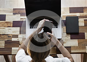 Woman`s hands use a smartphone with a laptop. Study and work online, freelance. Self employed or freelance woman, girl