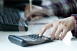 Woman`s hands using calculator on table