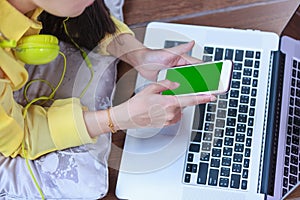 Woman`s hands using cell phone and laptop computer on floor wood