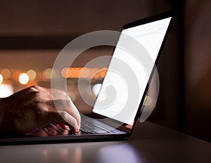 Woman`s hands using computer laptop with blank screen on desk in