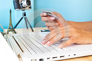 Woman`s hands using laptop and credit card for booking or reservation hotel and flight