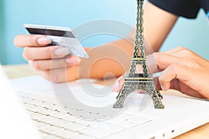 Woman`s hands using laptop and credit card for booking or reservation hotel and flight for Paris