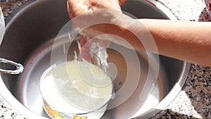 Woman`s hands washing dishcloth in kitchen sink.