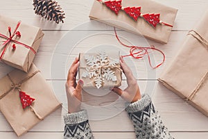 Woman`s hands wrapping christmas holiday present with craft twine