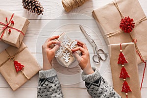 Woman`s hands wrapping christmas holiday present with craft twine