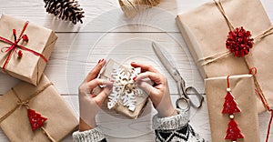 Woman's hands wrapping christmas holiday present with craft twine