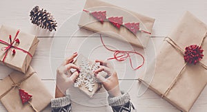 Woman`s hands wrapping christmas holiday present with craft twine