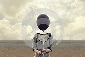 Woman`s head replaced by a black balloon