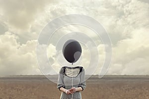 Woman`s head replaced by a black balloon photo