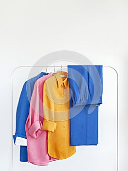 Woman\'s jacket, pants and linen shirts in bright colours with space for text.