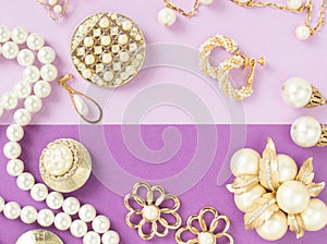 Woman`s Jewelry. Vintage jewelry background. Beautiful gold tone and pearls brooches, braceletes, necklaces and earrings on purpl