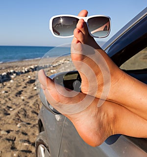 Woman's legs dangling out a car window