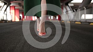 Woman`s legs in high heel shoes walking on road